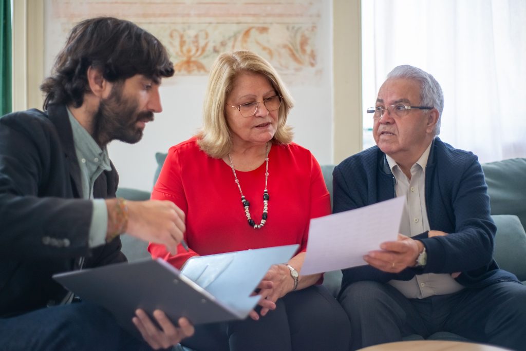 Couple reviewing financial documents with an advisor during a year-end planning meeting.